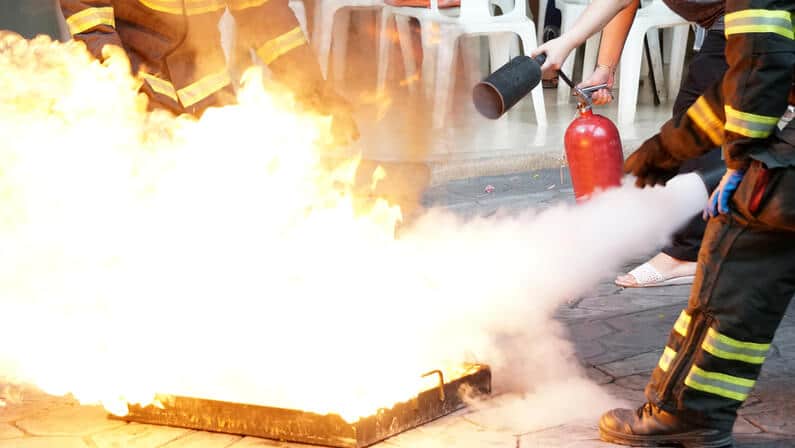 Fireman using fire extinguisher in a fire drill