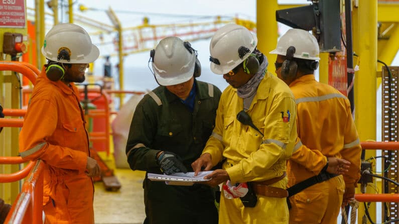 Offshore workers discussing safety checklist