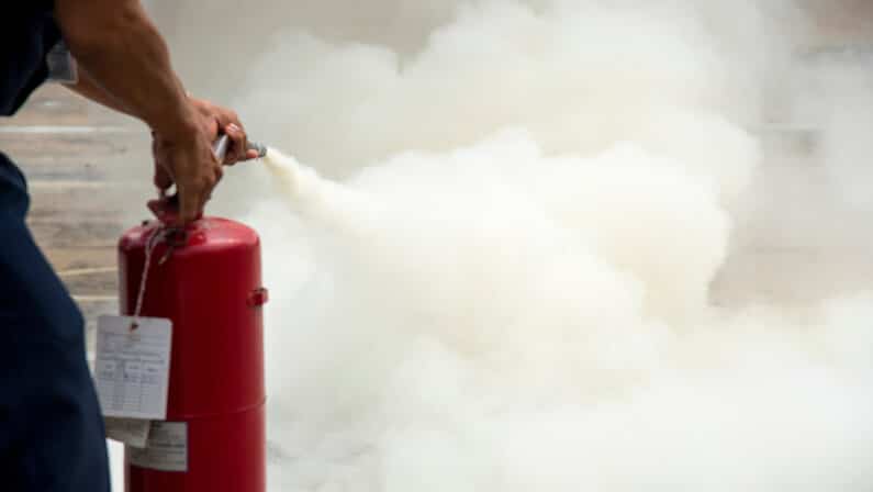 man practices using fire extinguishers