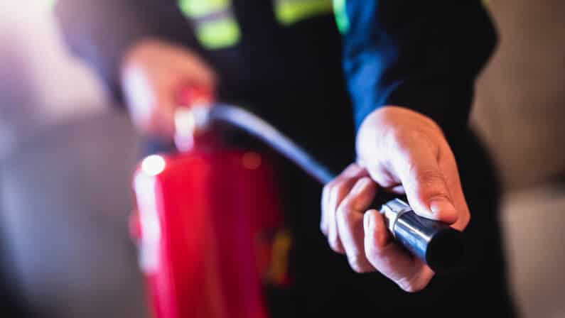 man using fire extinguisher