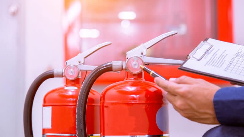 person checking fire extinguishers