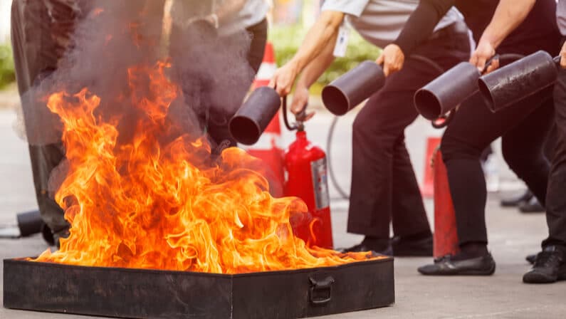 people doing fire drill using fire extinguishers