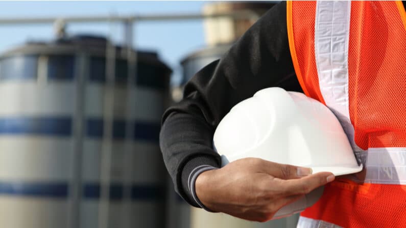 oil and gas worker holding safety hat